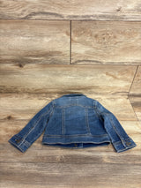 Back view of a children's blue denim jacket laid flat on wooden floor, kids resale clothing