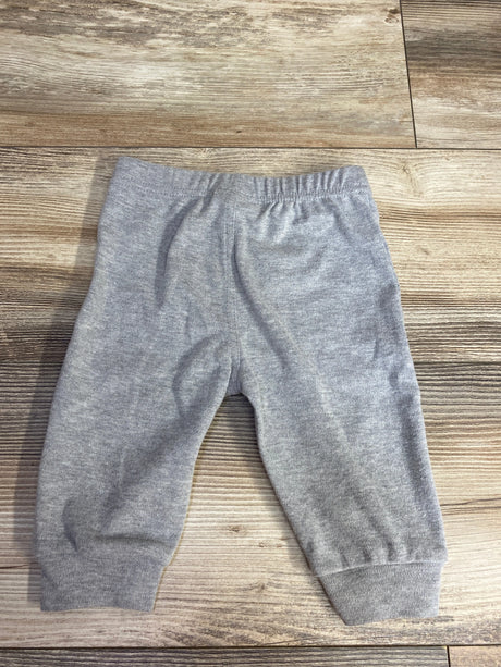 Gray baby sweatpants with elastic waistband and cuffs on wooden floor, children's resale clothing