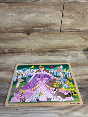 Top-down view of Melissa and Doug 24-piece wooden jigsaw puzzle featuring a princess with animals and flowers on a wood floor