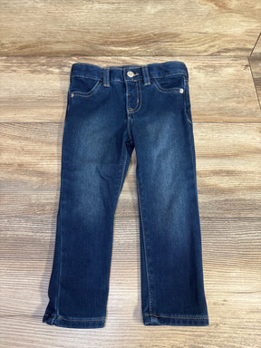Front view of Cat & Jack toddler blue jeggings size 2T laid flat with straight legs, faded thighs, button waist on wood background
