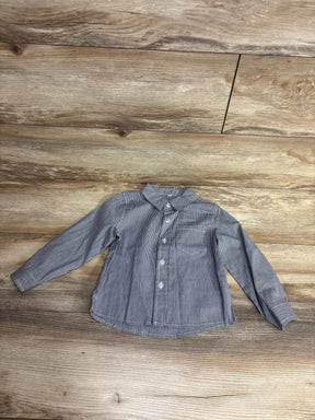 Gray and white checkered long sleeve button-up kids shirt on wood background