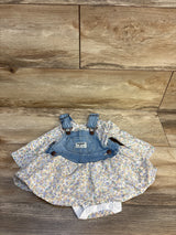 Floral baby romper dress with denim overall top on wood background