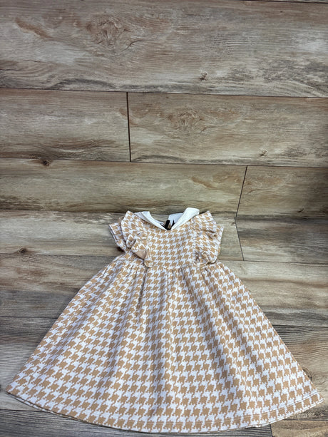 Flat lay of Janie & Jack houndstooth ruffle dress in butterscotch with ruffle sleeves and white collar on wood floor
