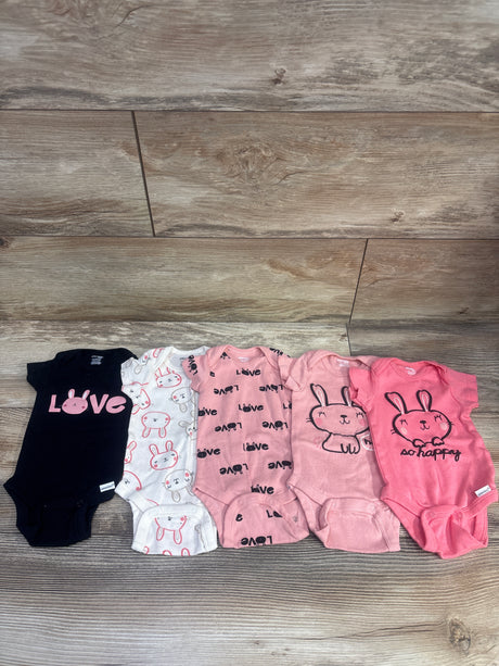 Top view of Gerber 5-pack bodysuit set in pink and assorted prints showcasing bunny designs on a wood floor