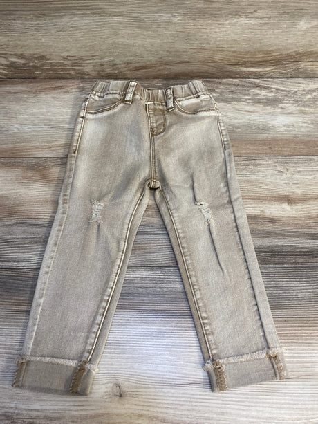 Light wash toddler jeans with elastic waistband and distressed knees on wood background
