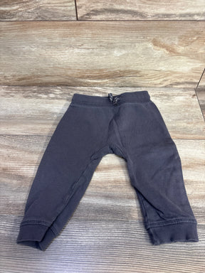 Front view of H&M grey baby drawstring joggers, size 9–12 months, showing elastic waistband with dotted drawstring and ribbed cuffs on wood background