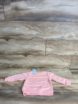 Light pink long-sleeve toddler sweater on wood plank background with price tag attached