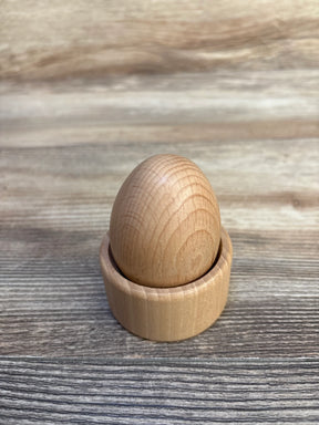 Front view of Lovevery Montessori Egg Cup showing smooth natural wood egg seated in a matching cup on a wooden tabletop