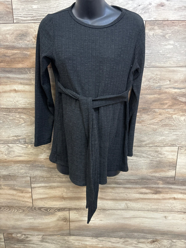 Front view of Ekouaer ribbed long-sleeve maternity top showcasing waist tie and textured fabric on wood-paneled background