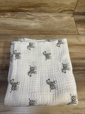 Top view of Amazing Baby muslin swaddle blanket in white with gray zebra print, laid flat on a wood floor