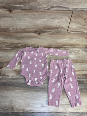 Pink baby onesie and leggings set with white bunny print, soft ribbed fabric, laid on wood floor