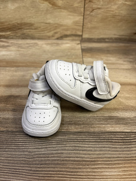 Angled view of Nike Court Borough Low 2 TD White Black sneakers showing perforated toes and hook-and-loop straps on wood grain