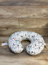U-shaped nursing pillow with black, red, and teal floral design on wood background