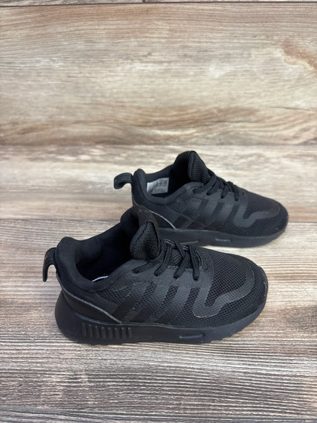 Angled view of Adidas Multix I toddler sneakers in triple black showing mesh upper, three stripes, laces and heel tab on wood background