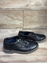 Side view of Steve Madden Toliverr cap-toe Oxford shoes with cap-toe stitch and white welt on wood floor