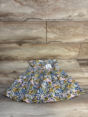 Infant floral dress with ruffled sleeves and colorful flower print on wood background