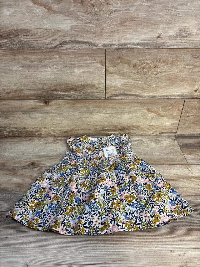 Infant floral dress with ruffled sleeves and colorful flower print on wood background