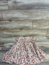 Flat lay of girls' ivory floral swing dress size 5T showing short ruffle sleeves and tiered skirt on light wood background