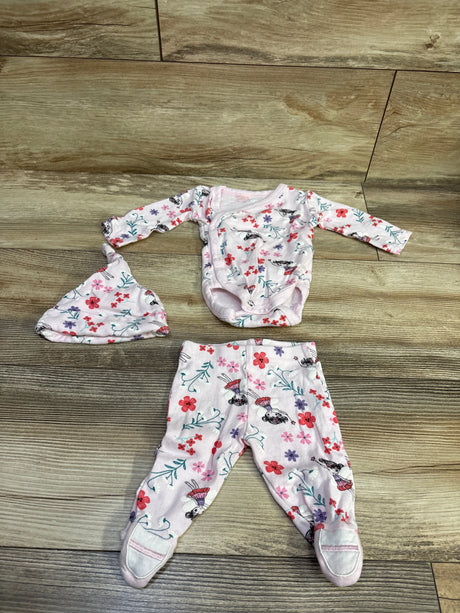 Flat lay of Koala Baby pink three-piece kimono bodysuit, pants, and hat set showcasing floral and character print on a wood floor