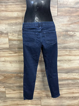 Back view of blue maternity jeggings showing side-panel waistband, back pockets, and tapered legs against wood plank background