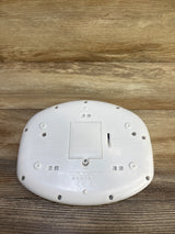 Bottom view of Baby Einstein Discover and Play Piano showing battery compartment and screw details on wood background