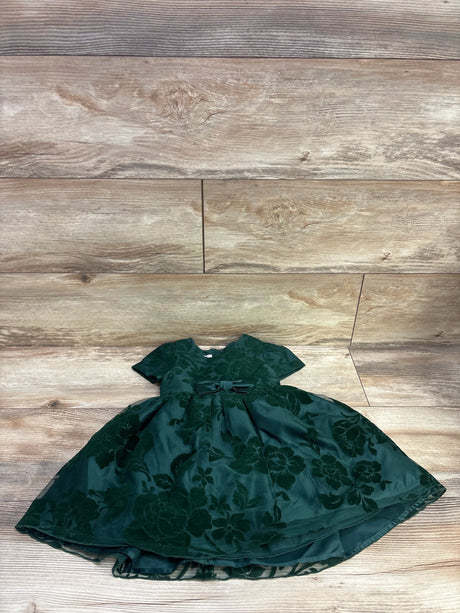 Top view of Katie M embroidered floral tulle dress in green, with bow waist and layered skirt on wood flooring