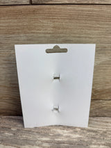 Front view of 2-pack hair bows display card showing two empty clip fastenings on a wood background