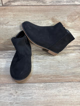 Black suede ankle boots for kids with side zipper on wood floor