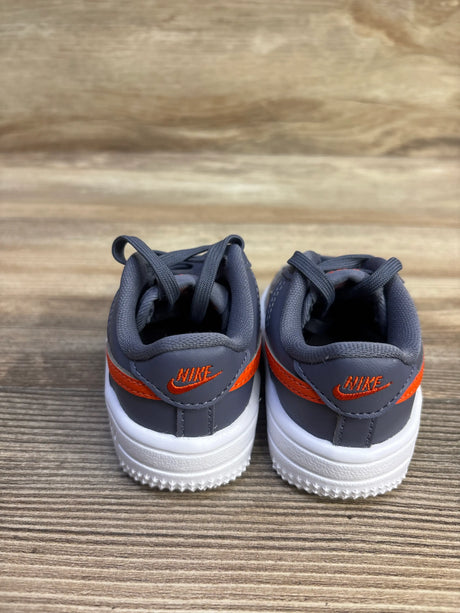 Rear view of Nike Force 1 Low TD Cement Grey Light Carbon sneakers in size 3C showcasing orange Nike logos and white soles on a wood surface