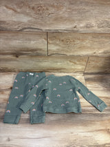 Flat lay of green waffle knit shirt and pants set showcasing rainbow print on a wood-look background