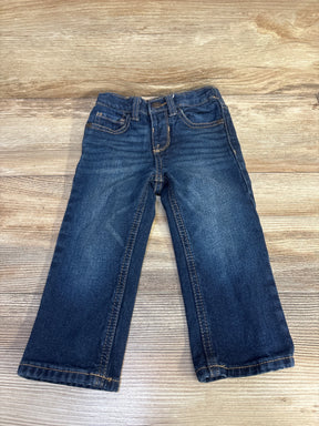 Front flat lay of Old Navy toddler straight-leg blue jeans showing front pockets, faded wash, and straight legs on wood background
