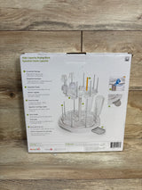 Front view of Munchkin High Capacity Bottle Drying Rack showing two-tier rack with adjustable pegs and removable drip tray on wood floor