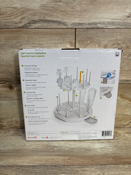 Front view of Munchkin High Capacity Bottle Drying Rack showing two-tier rack with adjustable pegs and removable drip tray on wood floor