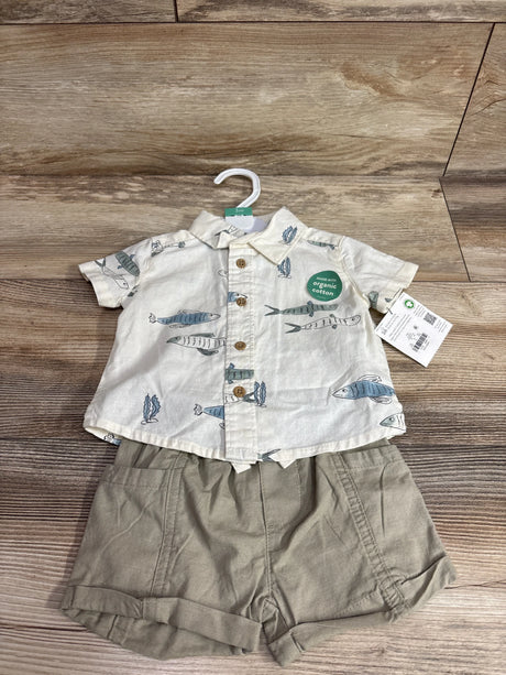 Flat lay of 2-piece baby set: fish-print button shirt and khaki shorts, showing organic cotton sticker on wood floor