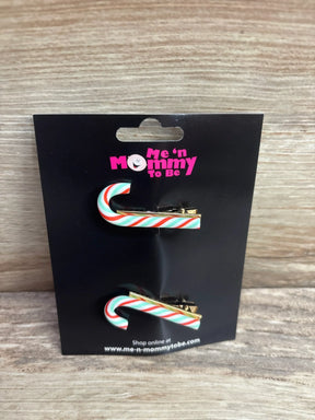 Candy cane hair clips with red, white, and green stripes on black packaging