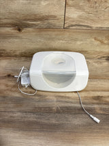 Front view of Munchkin Bright & Warm wipe warmer showcasing translucent flip lid and included power adapter on wooden tabletop background