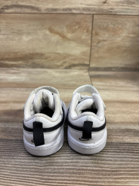 Rear view of Nike Court Borough Low 2 TD White Black sneakers size 3C showcasing black heel straps on wood-grain surface