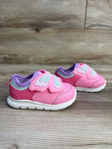 Pink toddler sneakers with butterfly wing design and white soles on wood floor