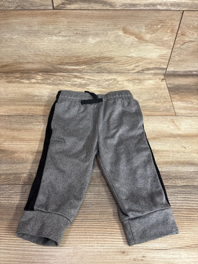 Flat lay of Jumping Beans boys' joggers 12 months, gray with black side stripe, elastic waist and cuffed hems on wood floor