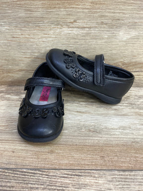Black toddler Mary Jane shoes with floral accents on wood background
