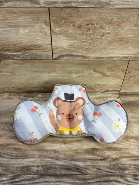 Front view of Taf Toys tummy time support pillow showing printed bear face and two side bolsters on wood floor background