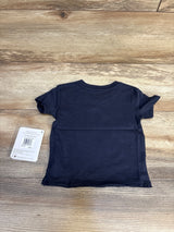 Midnight blue baby onesie, 12 months, with tag on wood floor — kids clothing resale