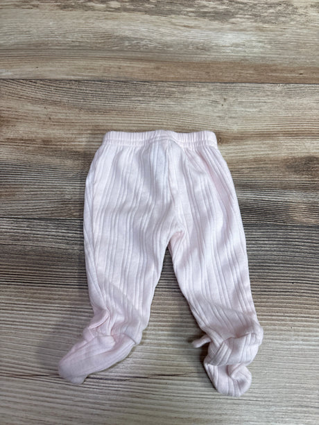 Front view of Child Of Mine pink preemie footed pants showcasing ribbed fabric and enclosed feet on a wood-grain background