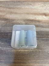 Two silicone baby finger toothbrushes in a clear case on wood surface