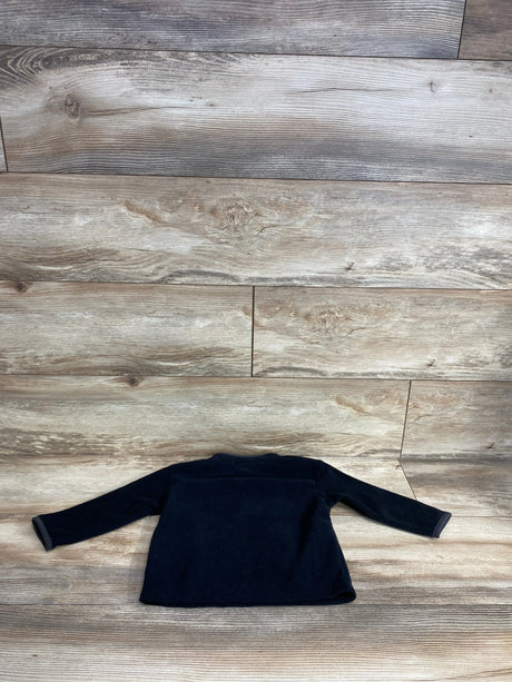 Black long sleeve toddler shirt displayed on wooden floor