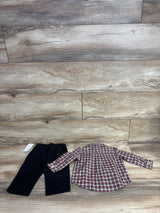 Children's outfit with black pants and red, white, and black plaid long-sleeve shirt on wood floor