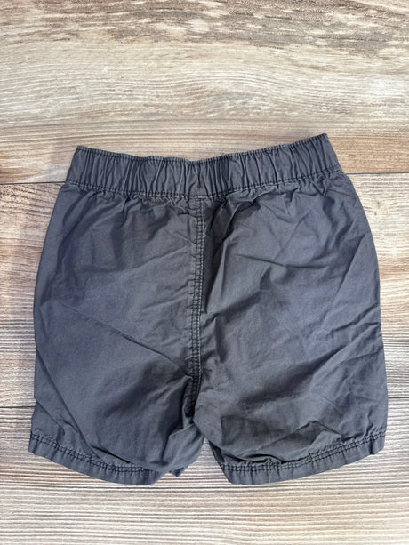 Flat lay of Old Navy grey drawstring shorts sz 18-24m showcasing elastic waistband and cotton fabric on wood plank background
