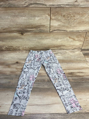Flat lay of grey Spotted Zebra Rock leggings showing all-over music and instrument doodle print with pink and teal accents on wood background
