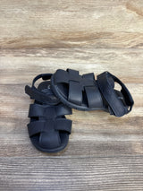 Top-down view of Nautica toddler fisherman sandals in navy showing woven straps and Velcro ankle strap on wood background