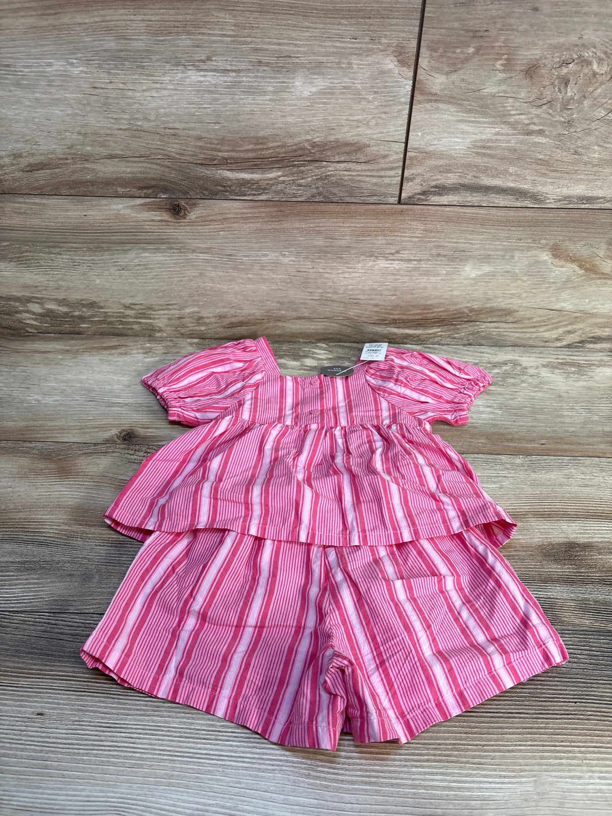 Pink and white striped baby romper with ruffled sleeves and tiered design